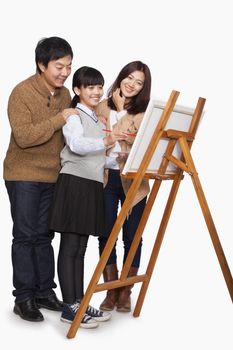Girl painting with parents