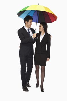 Businessman and businesswomen walking under colorful umbrella