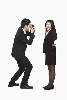 Businessman photographing businesswoman