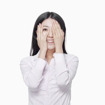 Young woman covering eyes with hands