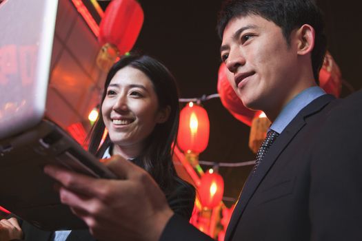 Coworkers working at night, City street, red lanterns on the background