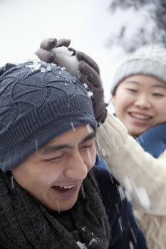 Young Couple Having a Snowball Fight