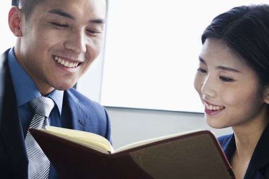 Co-workers checking agenda in office