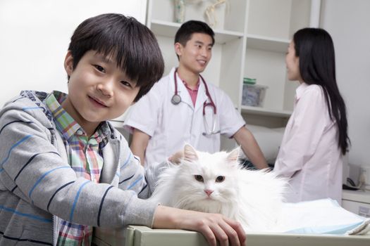 Boy with pet dog in veterinarian's office