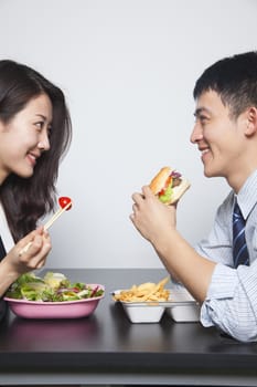 Two young business people eating a meal