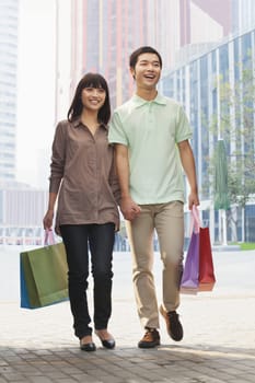 Young couple walking with shopping bags in hands, Beijing, China 