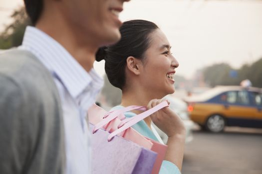 Young couple walking down the street with shopping bags in Beijing, close-up