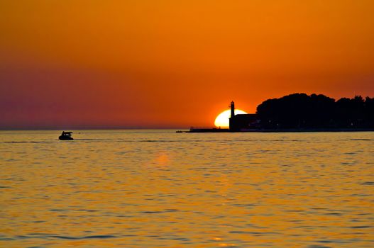 Lighthouse in Zadar and boat on the sea epic sunset, Dalmatia, Croatia