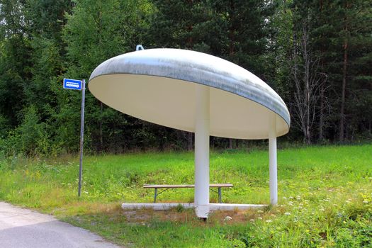 Bus stop shelter of a mushroom shape along road in Halikko, Salo, Finland. 