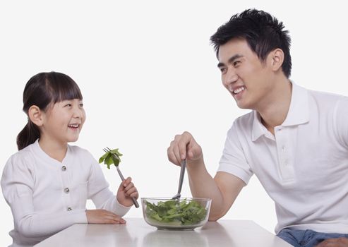 Father and Daughter sharing a salad, studio shot