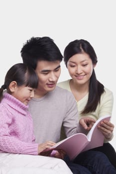 Family reading on the sofa, studio shot