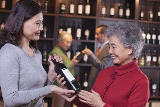 Two Women Examining Wine at a Wine Store