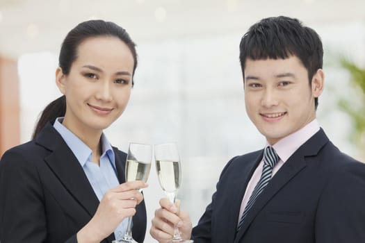 Young business man and woman toasting with champagne flutes