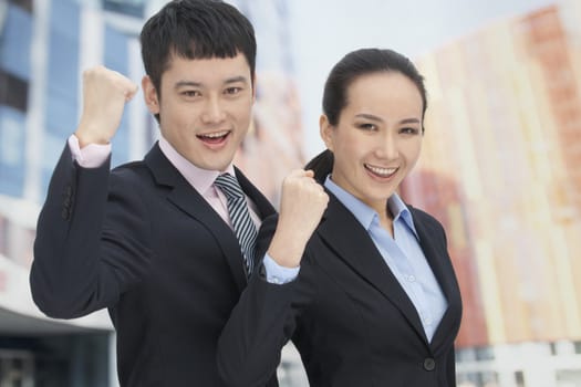 Young business man and woman cheering