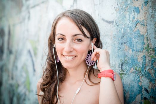 beautiful woman listening to music with phone player in the city