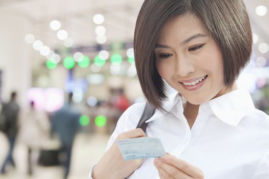 Young Woman Looking at a Train Ticket