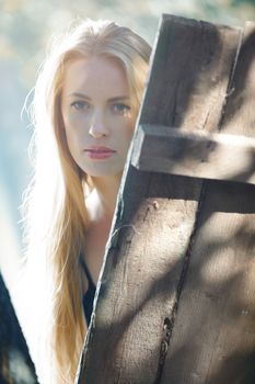 Blond lady behind the wood board during summer day