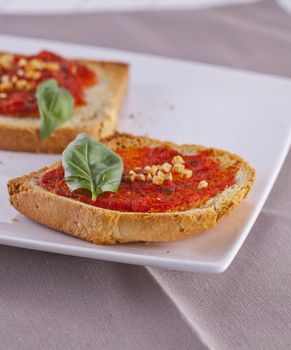 Close up of a couple of "bruschette" over a white plate