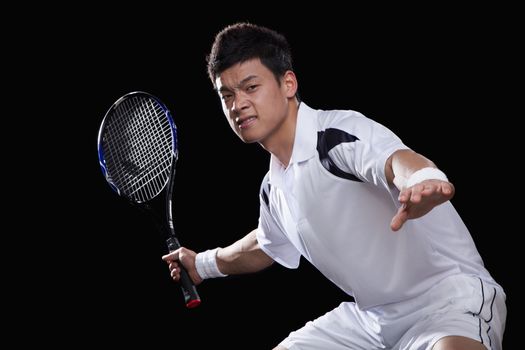 Tennis player ready to hit ball, portrait