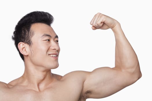 Young man showing off bicep