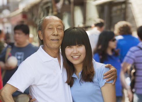 Portrait of grandfather and granddaughter together, outdoors in Beijing