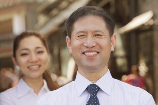 Portrait of two Business People, focus on businessman, outdoors, Beijing