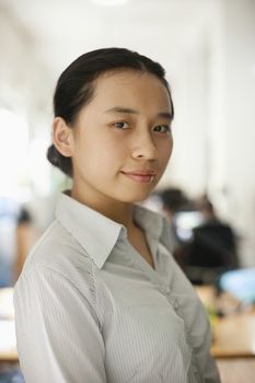 Young woman standing in the office, portrait