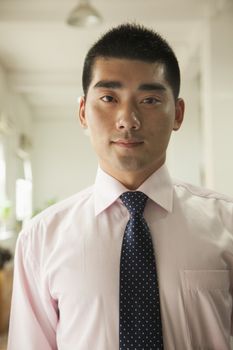 Young man standing in the office, portrait