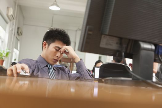 exhausted businessman sitting in front of computer