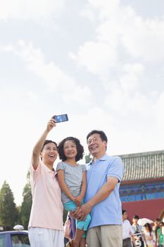 Grandparents and granddaughter taking self portrait with Cell Phone 