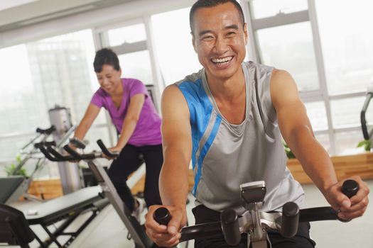 Man smiling and exercising on the exercise bike 