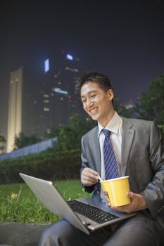Young businessman working outdoors and eating