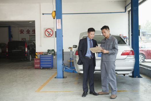 Garage Mechanic Explaining to Customer