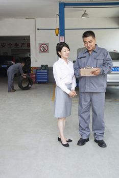 Garage Mechanic Explaining to Customer