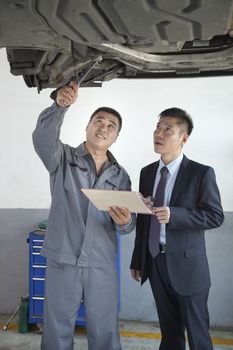Mechanic Explaining to Businessman 