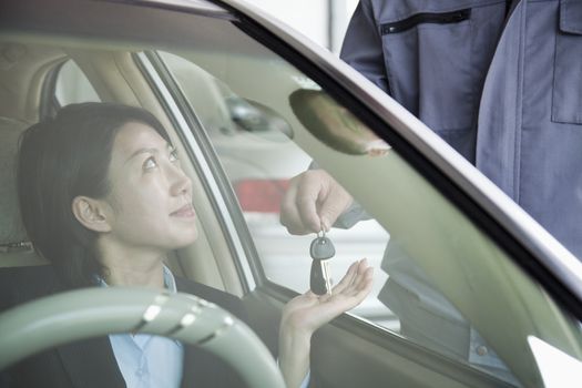 Mechanic Handing Keys to Businesswoman