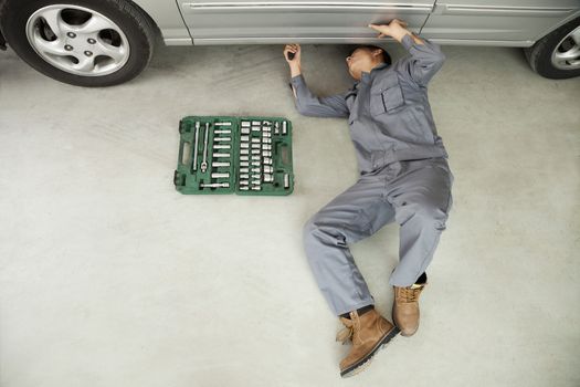 Mechanic Working on Underside of Car