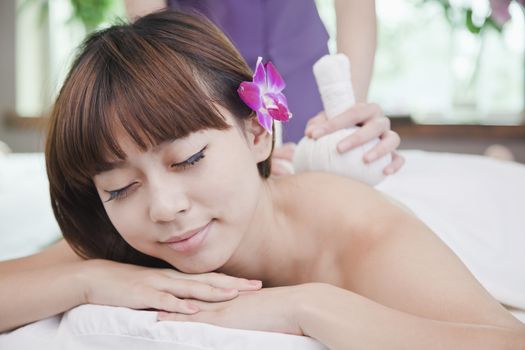 Woman Receiving Herbal Massage