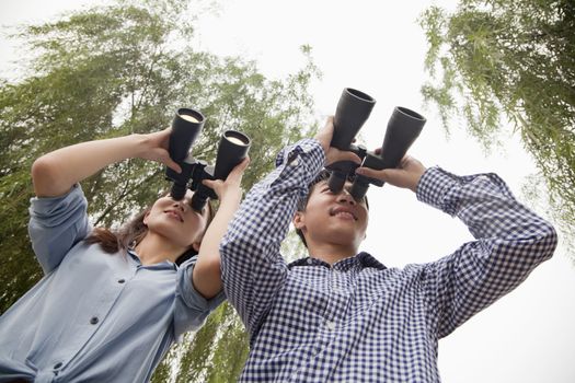 Young Couple Looking Out With Binoculars