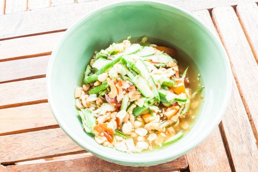 Thai style cucumber spicy salad serving n wooden table, stock photo