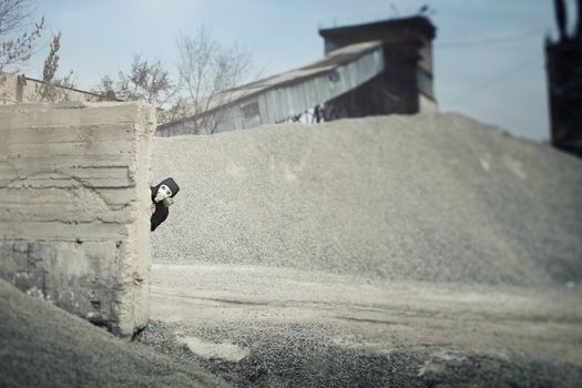 Human in the gas mask playing hide-and-seek at the industrial plant