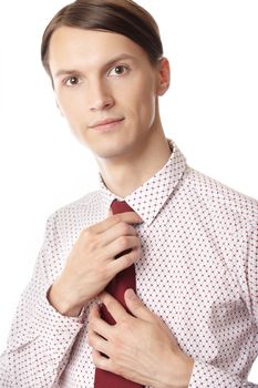 Successful businessman knotting red necktie on a white background
