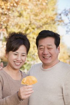 Mature Couple Looking at the Leaf in the Park