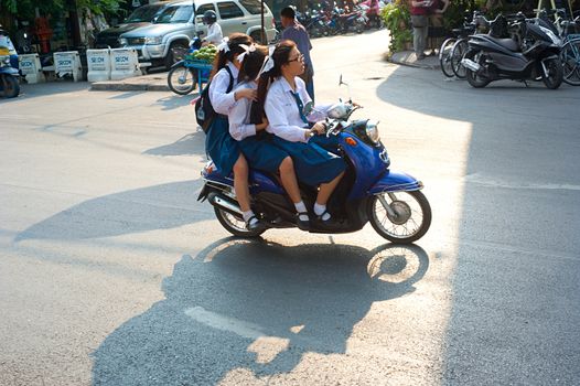 Chiang Mai, Thailand - Feb 27, 2013: Unidentified schoolgirls riding by motorbike in Chiang Mai, Thailand. Motorbike is the most popular and available transportation in South Asia.