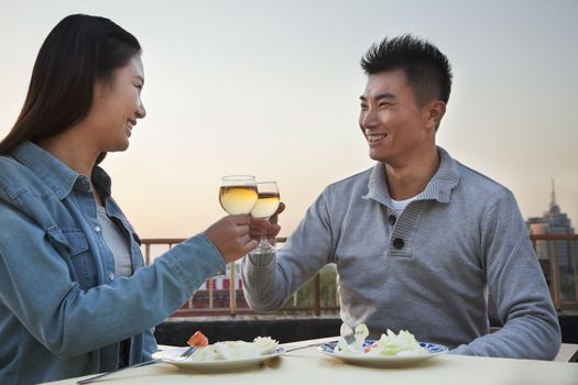 Young couple eating on the roof top, toast 
