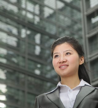 Portrait of young businesswoman outdoors among skyscrapers