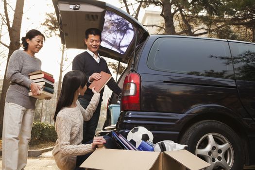 Parents unpacking car for a move to college, Beijing