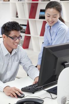 Happy coworkers working on their computer in the office