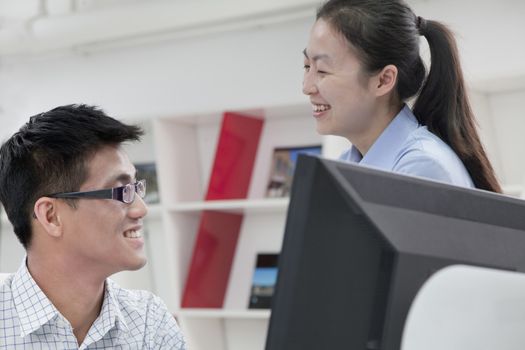Happy coworkers working on their computer in the office