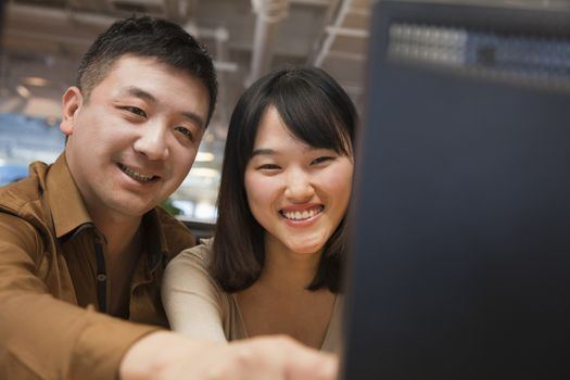 Two Business People Looking at Computer in the Office